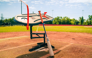 The Perfect Swings USA Swing Path Trainer set up over home plate on an outdoor diamond with the Perfect Swings USA Lag Bat.