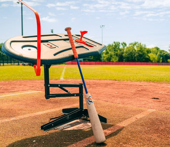 The Perfect Swings USA Swing Path Trainer set up over home plate on an outdoor diamond with the Perfect Swings USA Lag Bat.