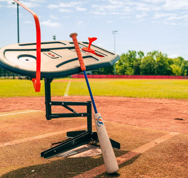 The Perfect Swings USA Swing Path Trainer set up over home plate on an outdoor diamond with the Perfect Swings USA Lag Bat.