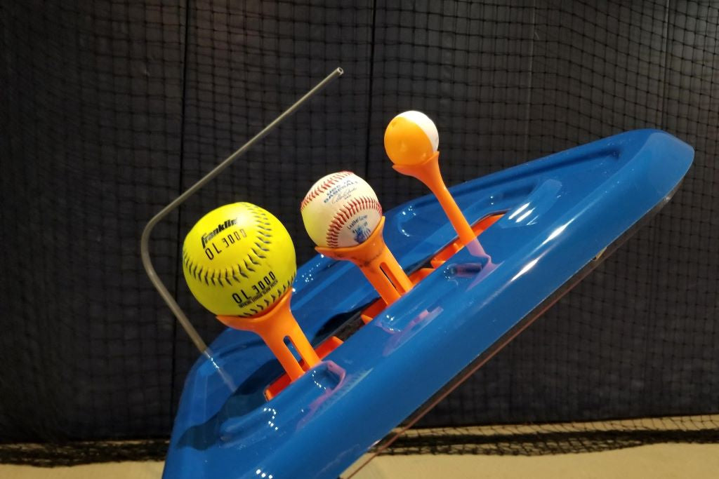 3 baseballs sitting on swing path trainer tee toppers